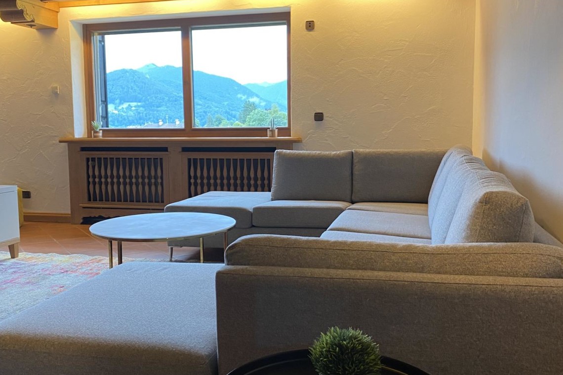 Gemütliches Apartment in Bad Wiessee mit Sofa, Bergblick, ideal für einen entspannten Urlaub.