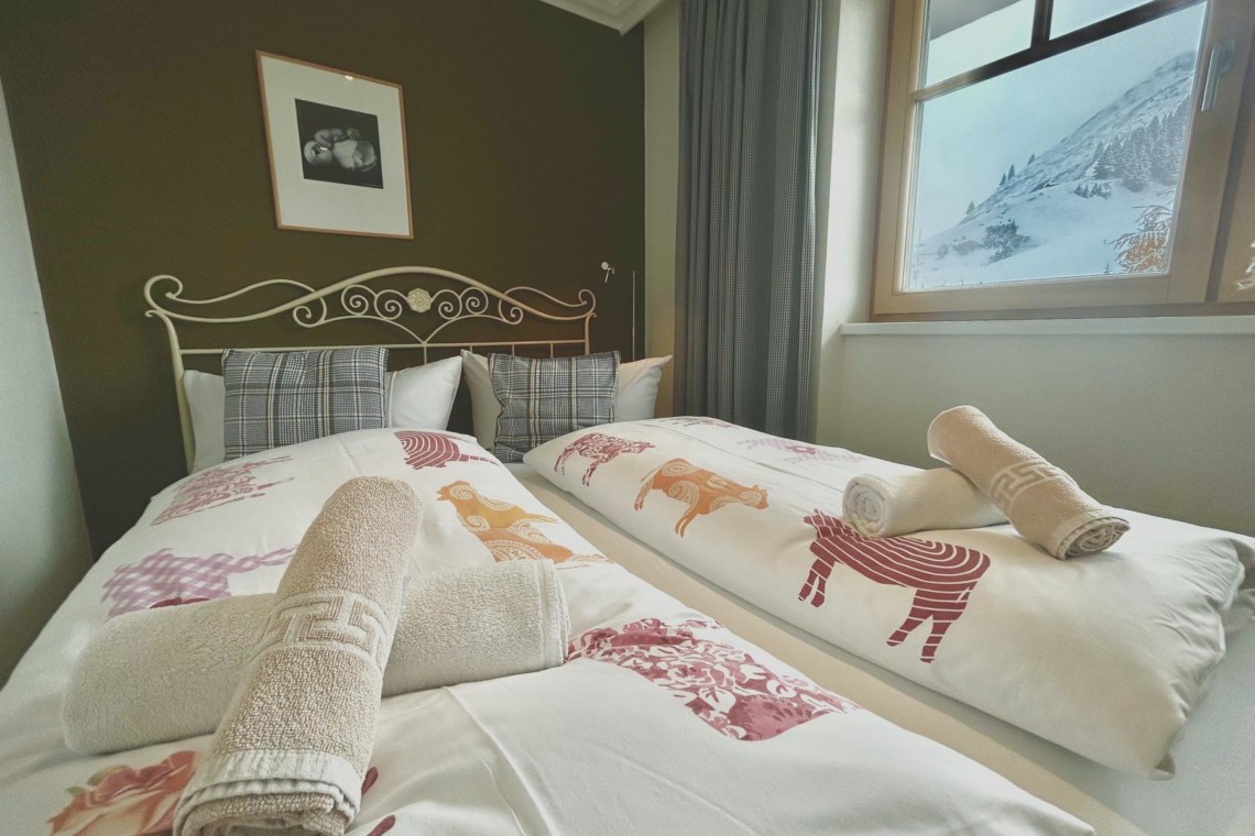 Gemütliches Schlafzimmer in einer Ferienwohnung in Warth am Arlberg, ideal für Entspannung nach dem Ski.