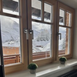 Gemütlicher Blick aus Fenster einer Ferienwohnung in Warth am Arlberg mit winterlicher Landschaft.