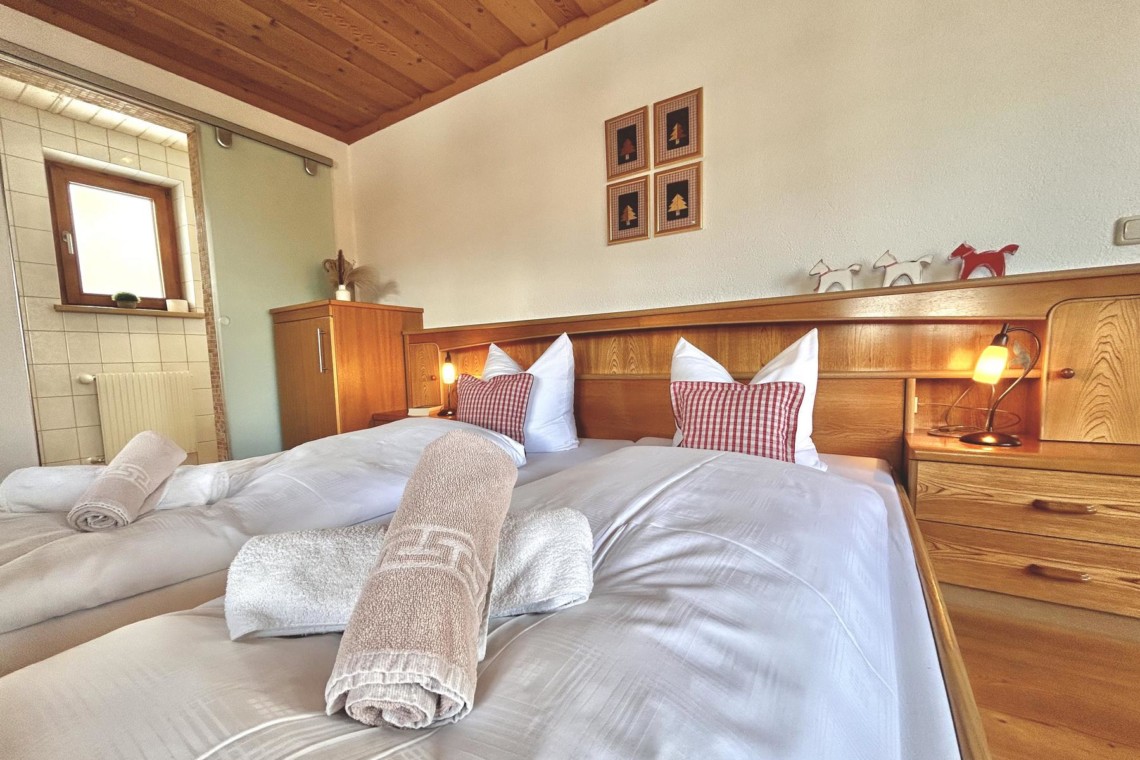 Gemütliches Schlafzimmer in Ferienwohnung Hillside One in Warth am Arlberg mit Holzakzenten und Bergenähe.