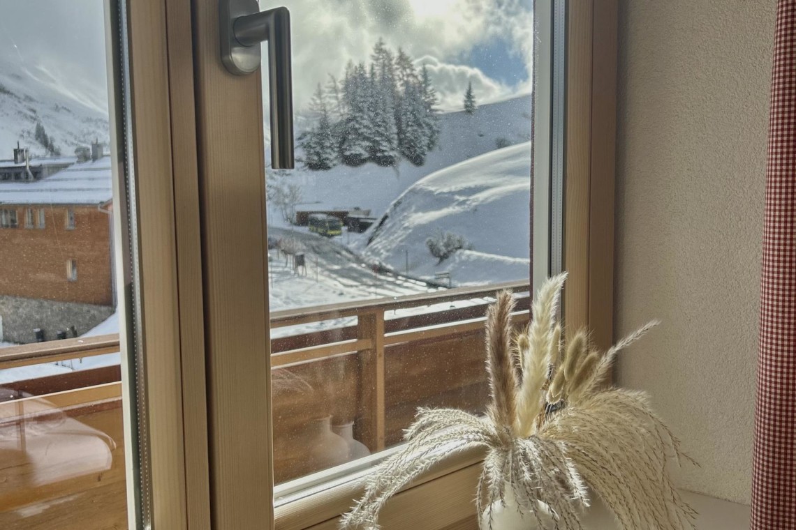 Gemütliches Ambiente mit malerischem Blick auf die schneebedeckten Berge von Warth am Arlberg. Ideal für eine entspannte Auszeit.