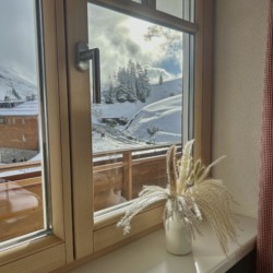 Gemütliches Ambiente mit malerischem Blick auf die schneebedeckten Berge von Warth am Arlberg. Ideal für eine entspannte Auszeit.