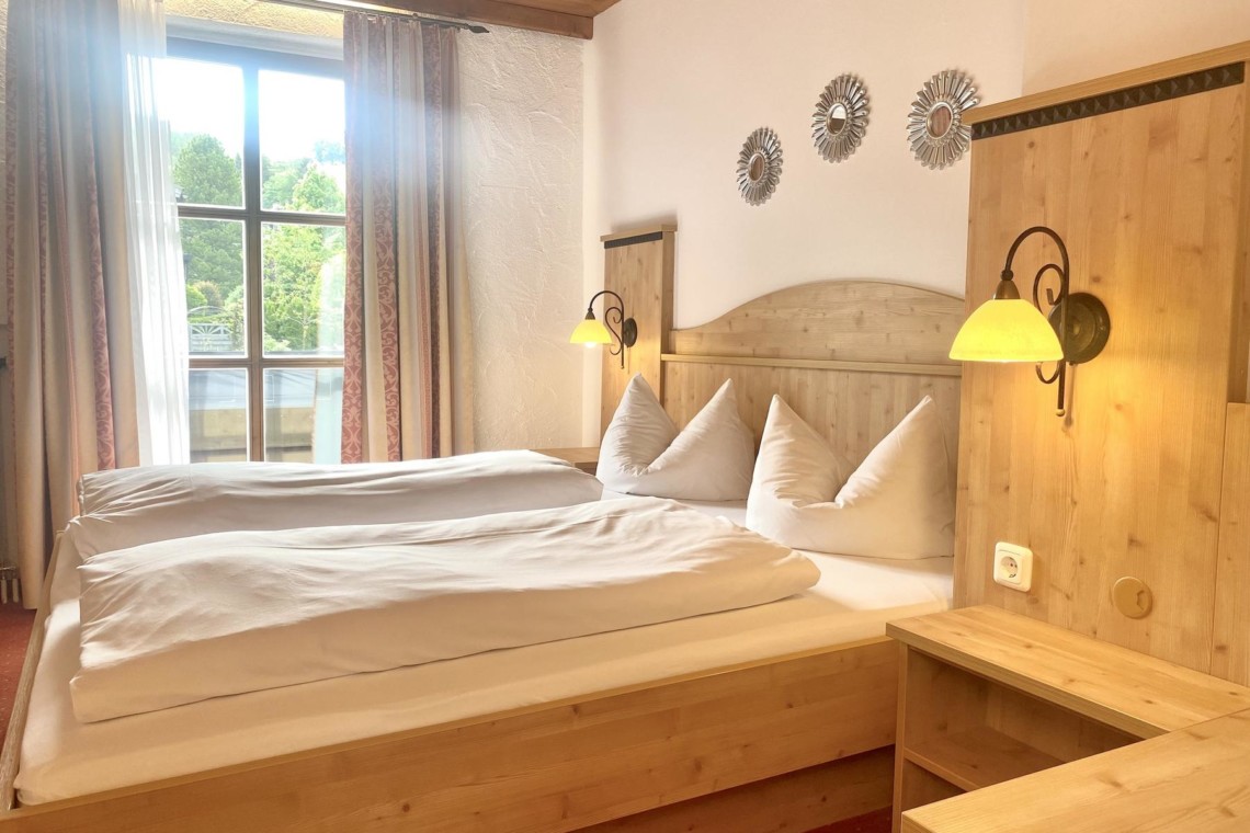 Gemütliches, helles Schlafzimmer mit Holzmöbeln in "Das Maximilian Romberg", Schliersee. Ideal für Ihren Urlaub.