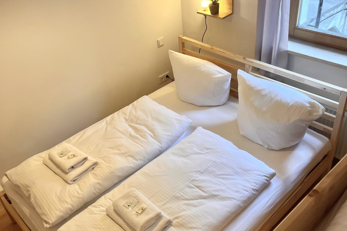 Gemütliches Schlafzimmer in Ferienwohnung, Bayrischzell, mit Holzmöbeln und hellem Ambiente.