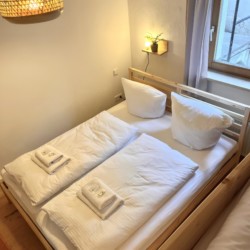 Gemütliches Schlafzimmer in Ferienwohnung, Bayrischzell, mit Holzmöbeln und hellem Ambiente.