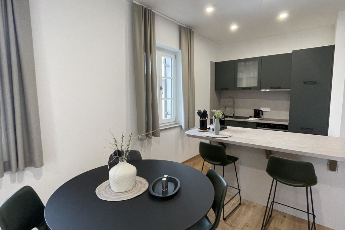Moderne Ferienwohnung in Gmund, stilvoll eingerichtete Küche mit Esstisch, helle Räume, ideal für Urlaub am Tegernsee. #GmundFerienwohnung