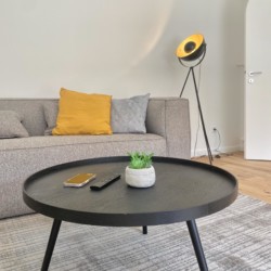Gemütliches Wohnzimmer in Rottach-Egern Ferienwohnung mit stilvollem Sofa, moderner Lampe & Deko. Ideal für Erholung.