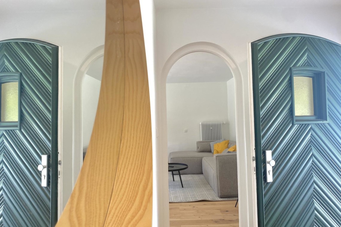 Gemütliches Interieur einer Ferienwohnung in Rottach-Egern mit stilvollen Türen und hellem Wohnzimmer.