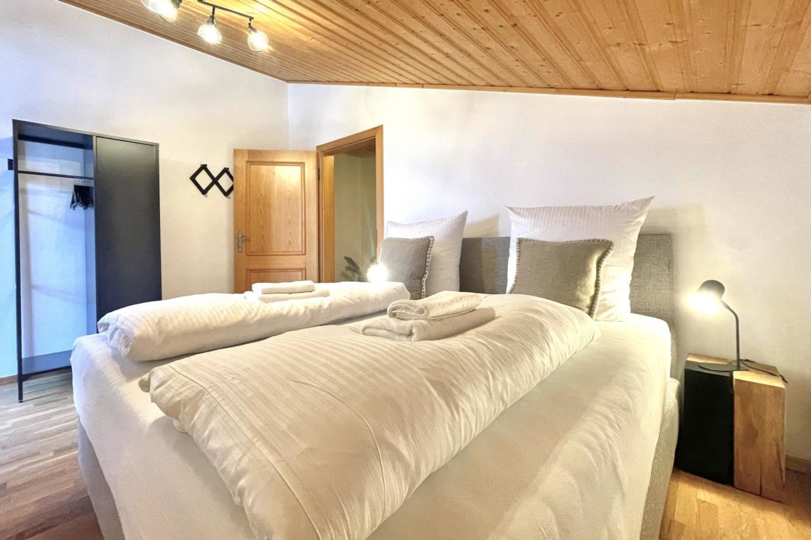 Gemütliches Schlafzimmer mit Doppelbett in einer Ferienwohnung in Rottach-Egern, nah am Tegernsee.