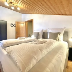 Gemütliches Schlafzimmer mit Doppelbett in einer Ferienwohnung in Rottach-Egern, nah am Tegernsee.