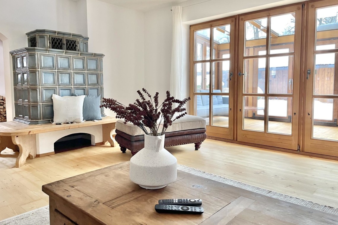 Gemütliches Wohnzimmer in Ferienhaus am Tegernsee, stilvolle Einrichtung, helle Atmosphäre und Holzelemente.