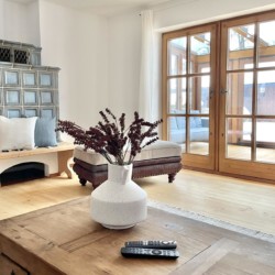 Gemütliches Wohnzimmer in Ferienhaus am Tegernsee, stilvolle Einrichtung, helle Atmosphäre und Holzelemente.