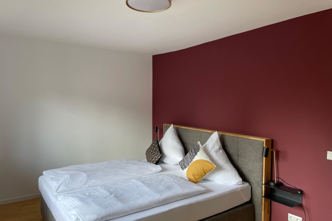 Gemütliches Bett in stilvollem Apartment am Tegernsee, ideal für Ihren Urlaub.