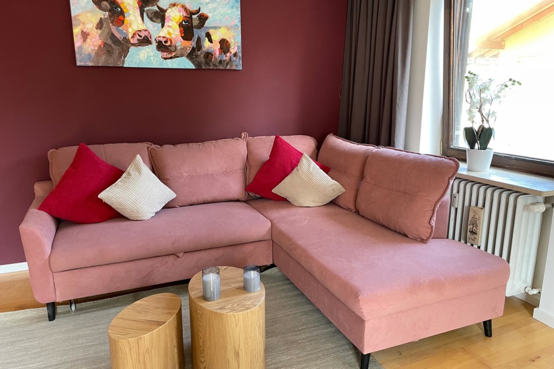 Gemütliches Apartment in Tegernsee, rosa Sofa, moderne Einrichtung, perfekt für Ihren Urlaub.