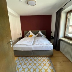 Gemütliches Schlafzimmer in Tegernsee Ferienwohnung mit modernem Design und Komfort. Ideal für einen entspannten Urlaub.
