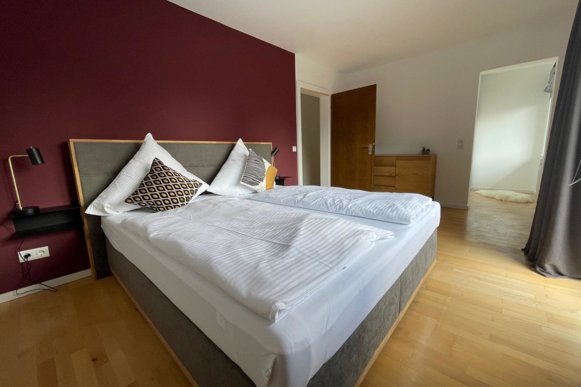 Gemütliches Schlafzimmer in Ferienwohnung am Tegernsee, ideal für Erholungssuchende.