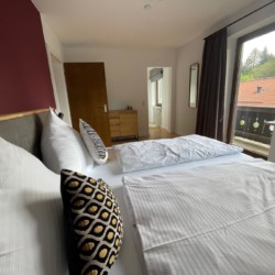 Gemütliches Schlafzimmer mit Doppelbett in heller Ferienwohnung am Tegernsee, ideal für Urlaub.