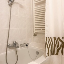 Gemütliches Bad einer Ferienwohnung in Bad Wiessee mit weißer Wanne und Dusche.