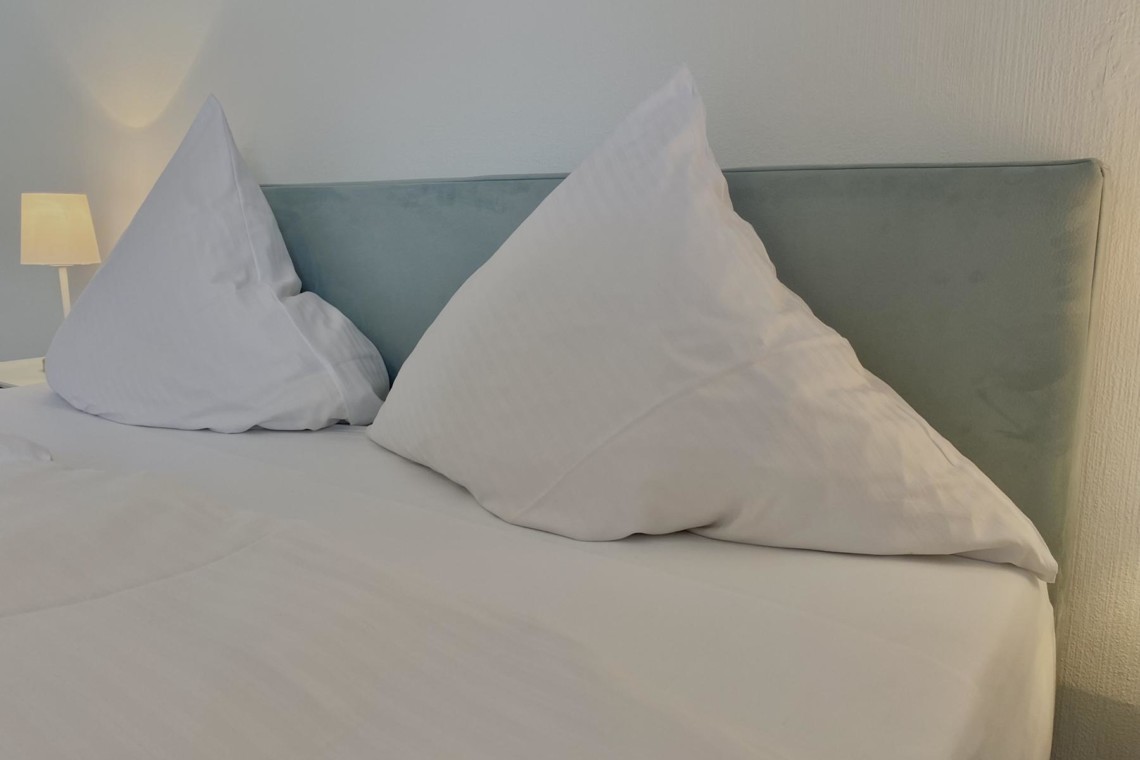 Gemütliches Schlafzimmer in Bad Wiessee Ferienwohnung mit komfortablen Kissen und modernem Flair.