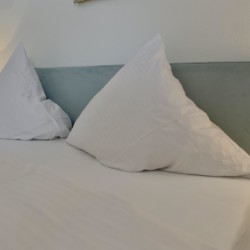 Gemütliches Schlafzimmer in Bad Wiessee Ferienwohnung mit komfortablen Kissen und modernem Flair.