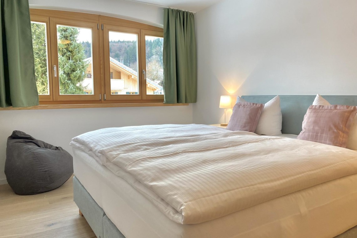 Helle, gemütliche FeWo in Bad Wiessee mit komfortablem Bett, Sitzsack und Bergblick. Ideal für einen entspannten Urlaub.
