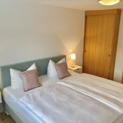 Gemütliches Schlafzimmer in Bad Wiesseer Ferienwohnung mit heller Einrichtung und Komfort.