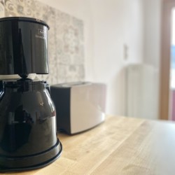 Gemütliche Küchenecke mit Kaffeemaschine und Toaster, helle Einrichtung und Ausblick – ideal für Urlaub in Bad Wiessee.