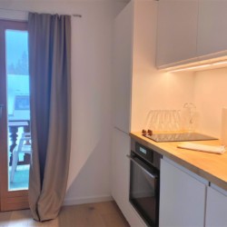 Helle, moderne Küche in einer Ferienwohnung in Bad Wiessee mit Terrassenzugang und stilvoller Einrichtung.