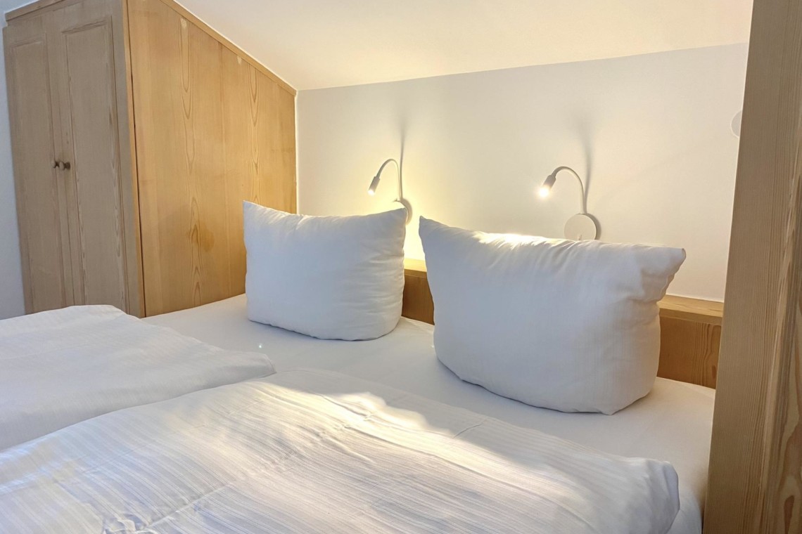 Gemütliches Schlafzimmer in Dachgeschoss-Ferienwohnung in Bad Wiessee, hell und einladend. Buchen Sie jetzt auf stayfritz.com.