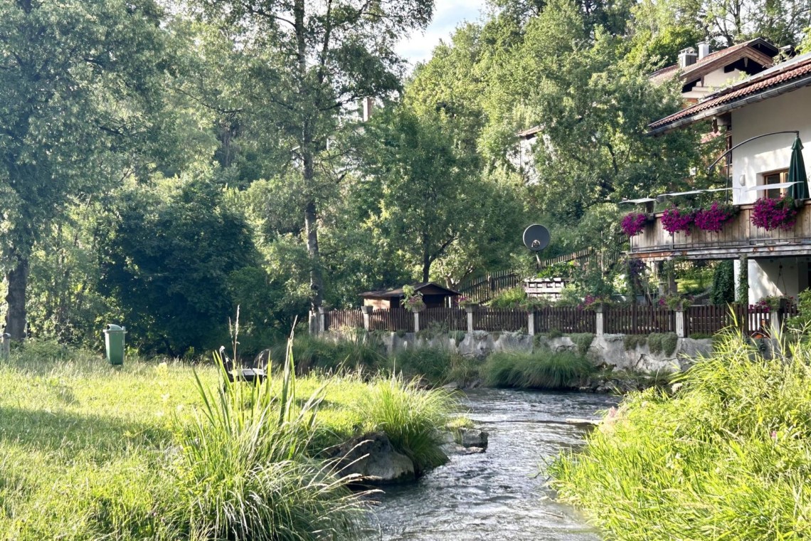 Idyllische Ferienwohnung in Hausham mit Blick auf einen Bach, umgeben von grüner Natur und ruhiger Atmosphäre. Ideal für Erholung.
