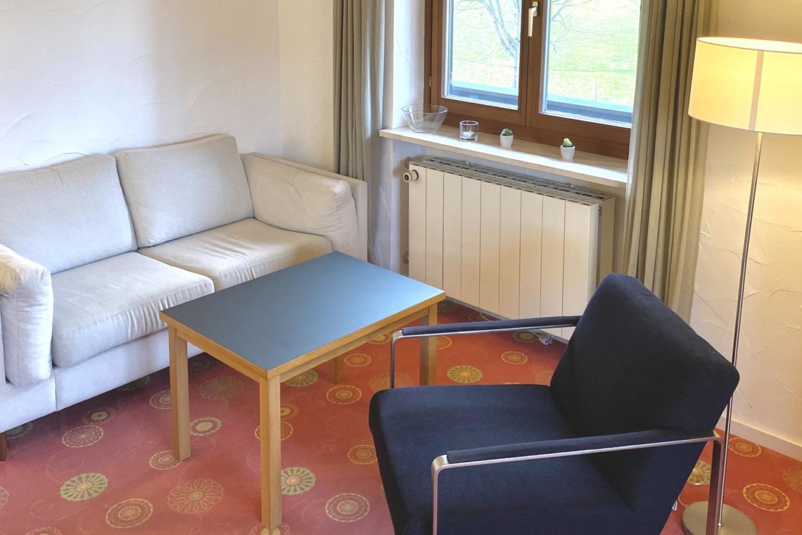 Helles Studio in Bad Wiessee: Gemütliche Couch, Sessel, Tisch, viel Licht. Ideal für Ihren Urlaub!
