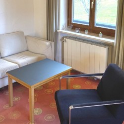 Helles Studio in Bad Wiessee: Gemütliche Couch, Sessel, Tisch, viel Licht. Ideal für Ihren Urlaub!