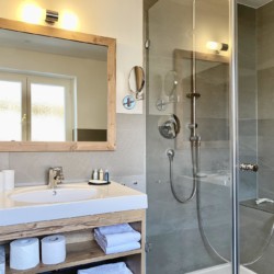 Modernes Badezimmer in Ferienwohnung, Bad Wiessee. Komfortabel mit Dusche & stilvollem Waschplatz.