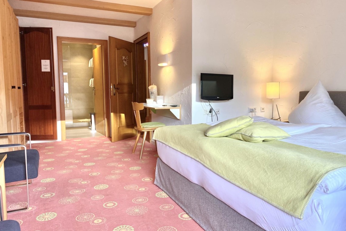 Gemütliches Zimmer in Bad Wiessee mit bequemem Bett, TV und modernem Bad. Ideal für Erholungssuchende.