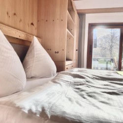 Gemütliches Schlafzimmer in Ferienwohnung am Tegernsee mit Balkon und Aussicht. Ideal für Urlaub in Bad Wiessee.