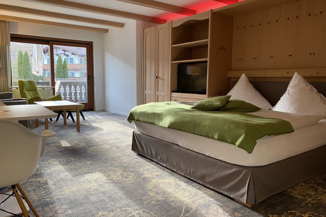 Gemütliches Schlafzimmer in einer Superior Alpine Suite, Bad Wiessee, mit modernem Dekor und Balkonzugang.
