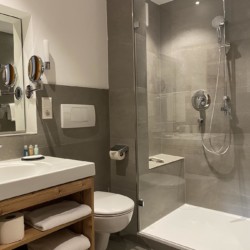 Moderne Superior Alpine Suite in Bad Wiessee, stilvolles Badezimmer mit Dusche. Ideal für entspannten Urlaub. Buchen auf stayfritz.com.