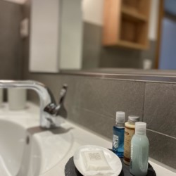 Moderne Ferienunterunft Bad Wiessee: elegant ausgestattetes Badezimmer mit Pflegeprodukten. Ideal für erholsamen Urlaub.