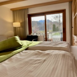 Gemütliches Schlafzimmer in Ferienwohnung in Bad Wiessee mit Balkonblick auf Natur.