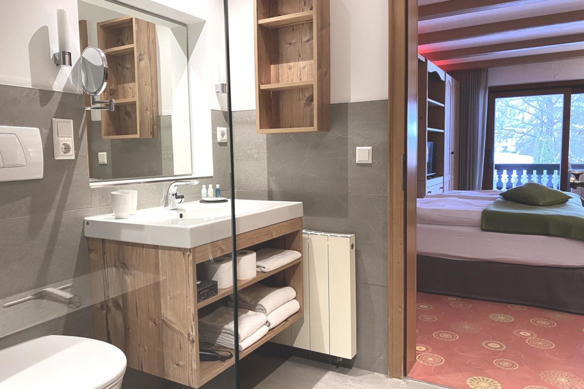 Gemütliches Bad mit Blick ins Schlafzimmer einer modernen Ferienwohnung in Bad Wiessee.