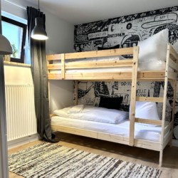 Gemütliches Schlafzimmer mit Etagenbett in Schlierseer Ferienwohnung, stilvoll gestaltet für Entspannung.