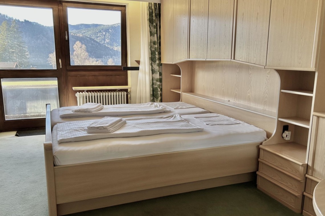 Gemütliches Schlafzimmer mit Doppelbett und tollem Seeblick am Schliersee. Ideal für eine erholsame Auszeit im Urlaub.