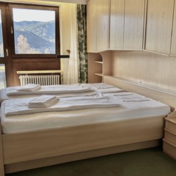 Gemütliches Schlafzimmer mit Doppelbett und tollem Seeblick am Schliersee. Ideal für eine erholsame Auszeit im Urlaub.