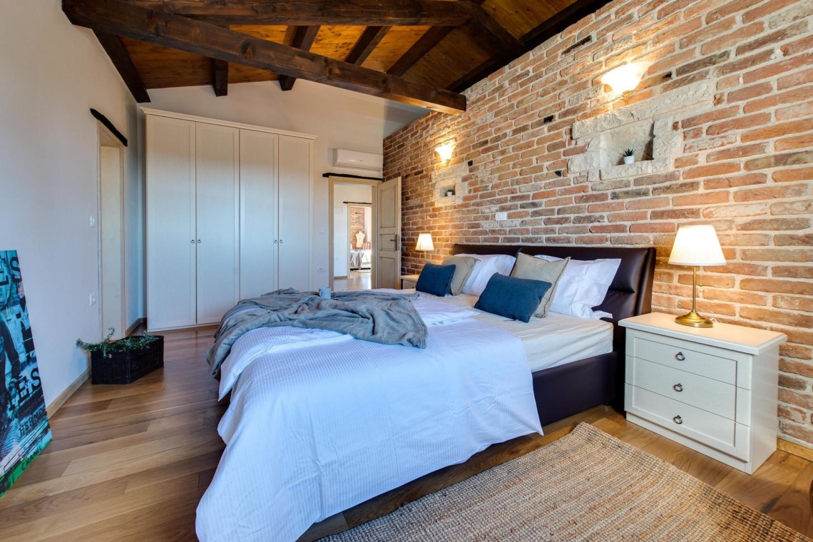 Gemütliches Schlafzimmer in der Villa Avalon, Muntrij. Charmantes Ambiente mit Holzbalken und Backstein für idealen Urlaub. #stayFritz