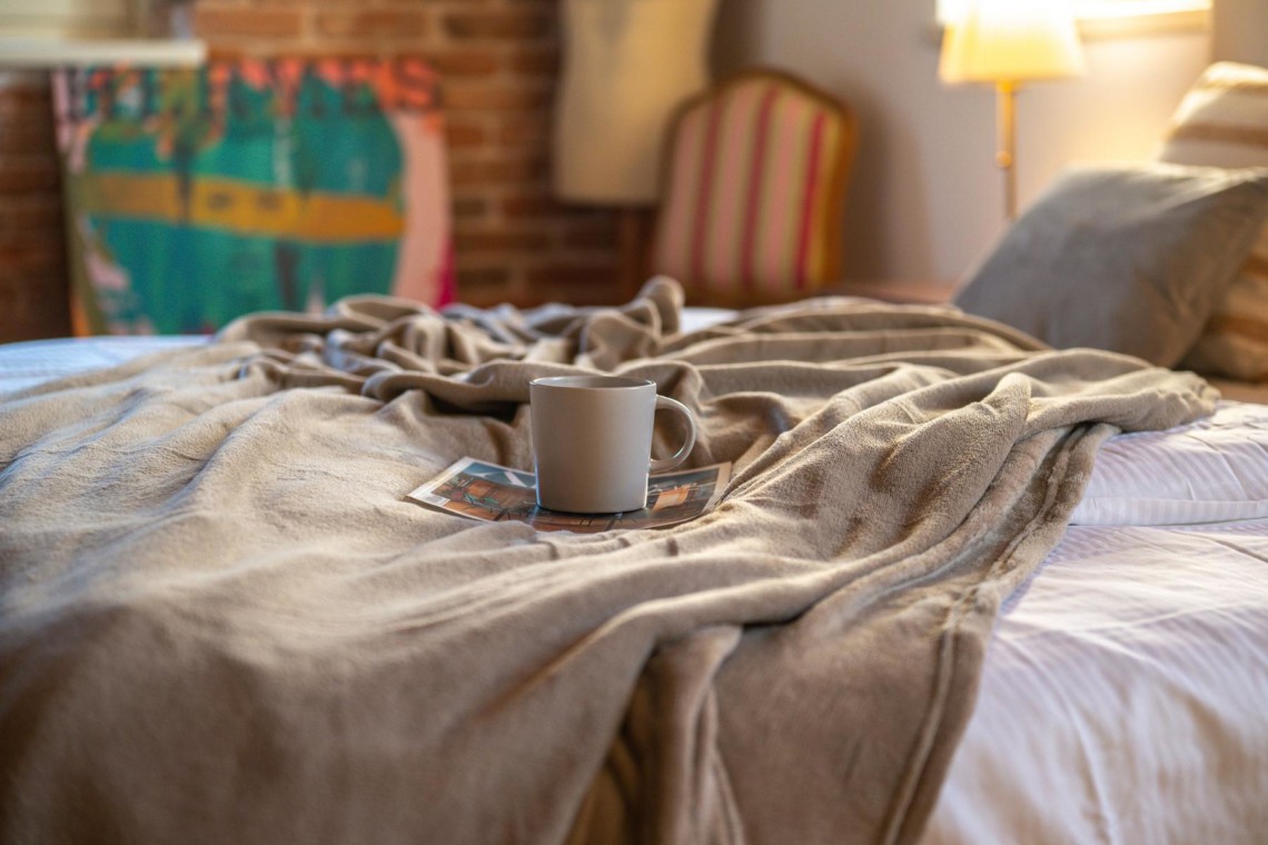 Gemütliches Bett in Villa Avalon, Muntrij, mit Kaffee für entspannten Start in den Tag. Ideal für Urlaub.