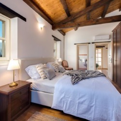 Gemütliches Schlafzimmer in Villa Avalon, Muntrij mit Holzbalken, rustikalem Charme und modernen Annehmlichkeiten. Ideal für Urlaub.
