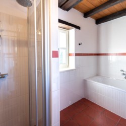 Helles Badezimmer mit Dusche und Badewanne in der Villa Avalon, ideal für Ihren Aufenthalt in Muntrij.
