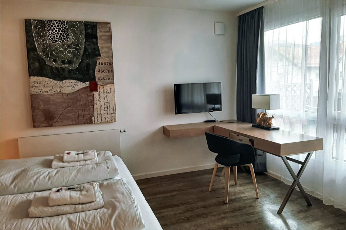 Gemütliches Zimmer in Schliersee Ferienwohnung mit modernem Dekor, TV und hellem Arbeitsbereich.