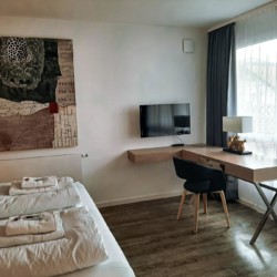 Gemütliches Zimmer in Schliersee Ferienwohnung mit modernem Dekor, TV und hellem Arbeitsbereich.