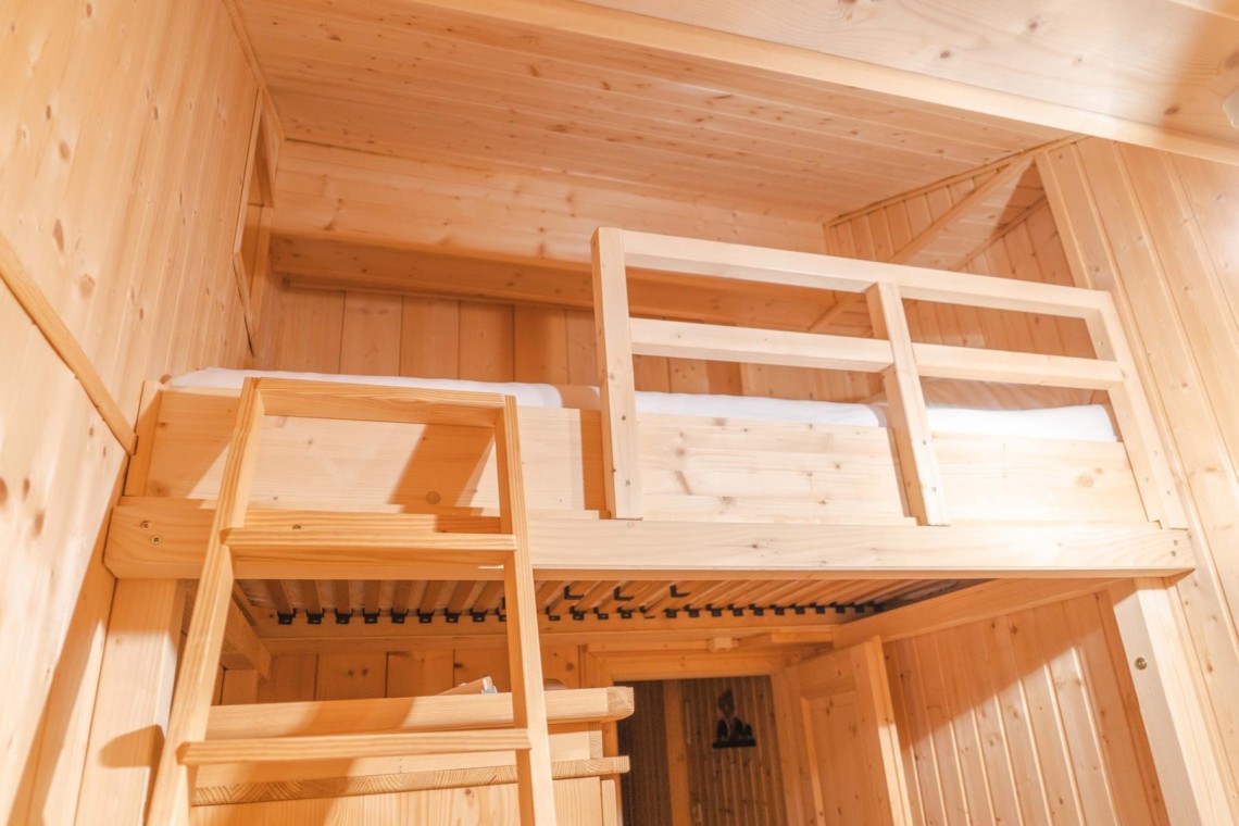 Gemütliches Chalet-Zimmer in Geitau mit Hochbett aus Holz, ideal für erholsame Bergferien. Buchen Sie jetzt bei stayFritz!